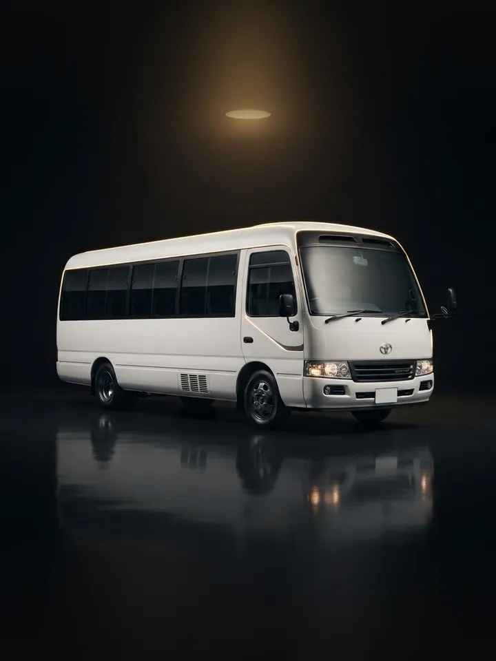 White Toyota Coaster minibus in a dark studio